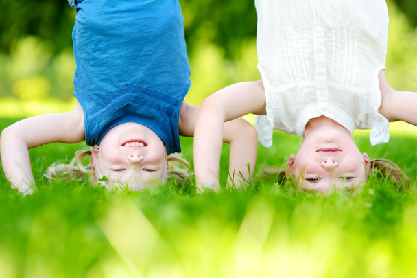 kinderen spelen hals over kop op groen gras - Foto, afbeelding