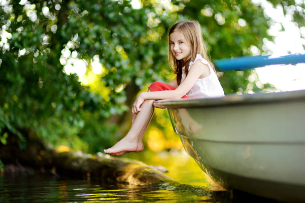 girl having fun in a boat by a river - Photo, image
