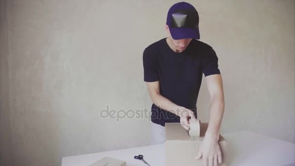 Postman Seals Box Adhesive Tape Prepares Order For Shipment at Work Place Inside. - Footage, Video