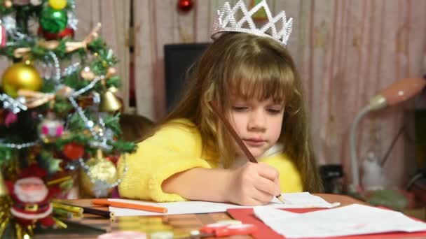 The girl draws at the table Christmas drawing - Кадри, відео
