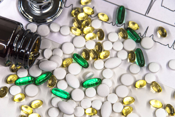 Σωρός από λευκό πράσινο κίτρινο στρογγυλό καψάκιο χάπια με αντιβιοτικό φάρμακο στα πακέτα. - Φωτογραφία, εικόνα