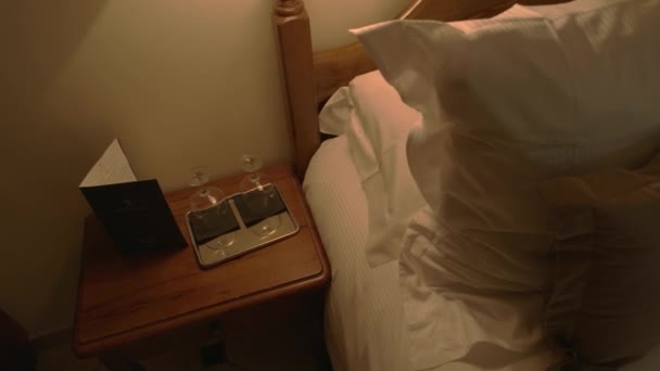 Tray with wineglasses near bed. - Filmati, video