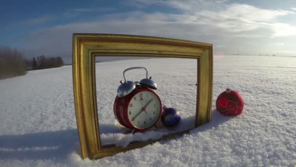 Golden art frame on field snow, Christmas bauble and clock, time lapse 4K - Footage, Video