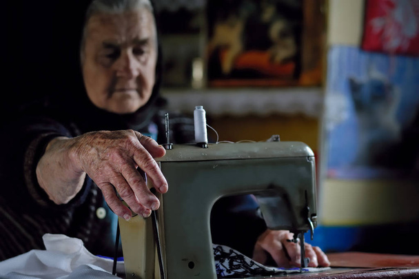 Old woman using sewing machine - Fotografie, Obrázek