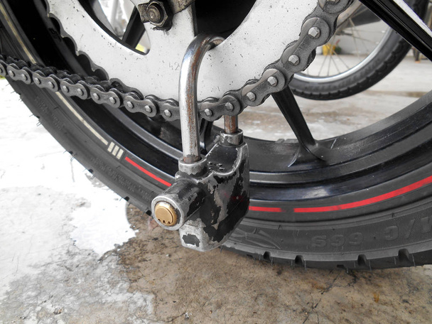 Oude hangslot vergrendeling motorfiets wiel  - Foto, afbeelding