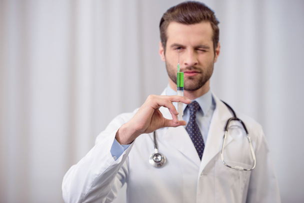 Doctor holding syringe - Foto, afbeelding