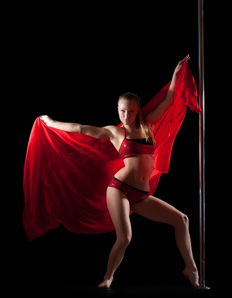 Woman posing in pole dance with red silk fabric - Photo, image
