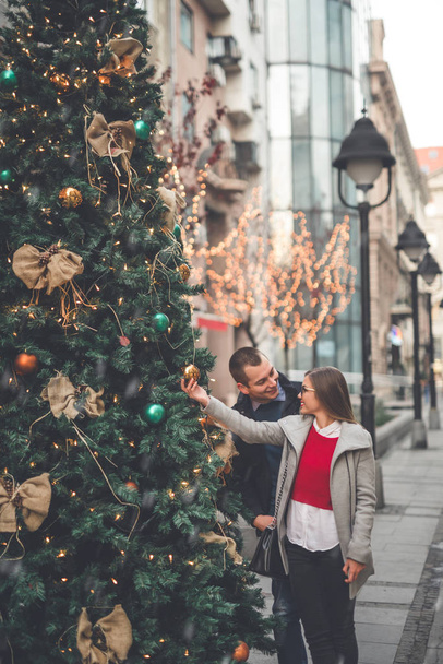 Couple enjoying in Christmas decorated street  - Fotografie, Obrázek