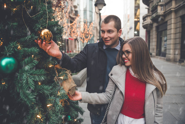 Couple enjoying in Christmas decorated street  - Fotografie, Obrázek