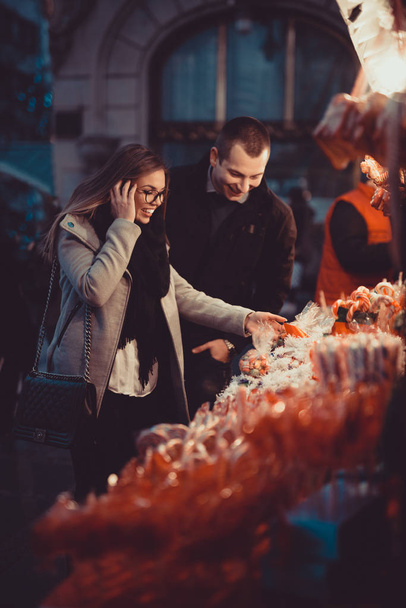 Couple bying lollipops on street on Valentine's day - Фото, изображение