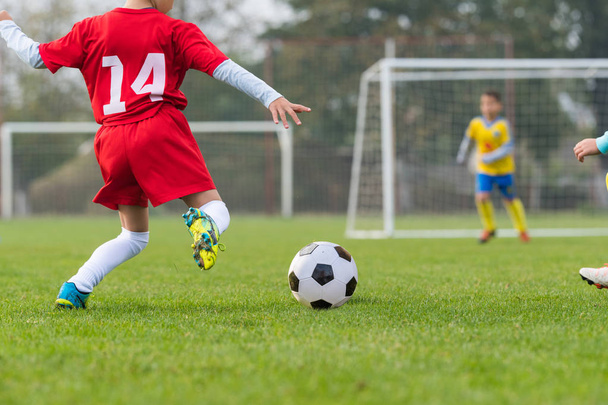 Rapaz chutando bola de futebol
  - Foto, Imagem