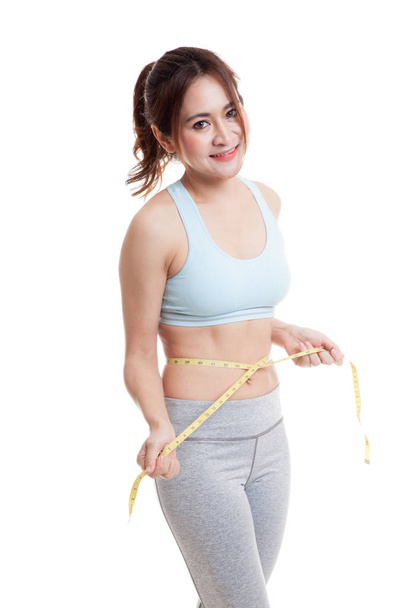 Beautiful Asian healthy girl measuring her waist. - Фото, изображение