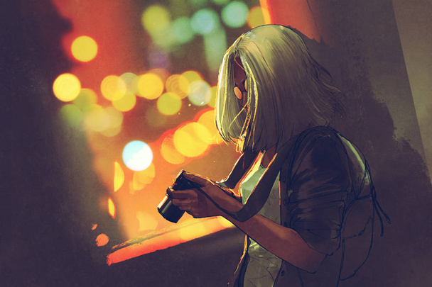woman holding a camera near the window on the night city - Zdjęcie, obraz
