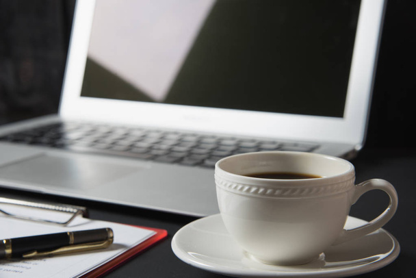Tasse Kaffee und Laptop auf dem Tisch - Foto, Bild