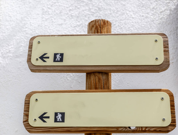 Dos letreros de madera con flechas indicativas
 - Foto, imagen