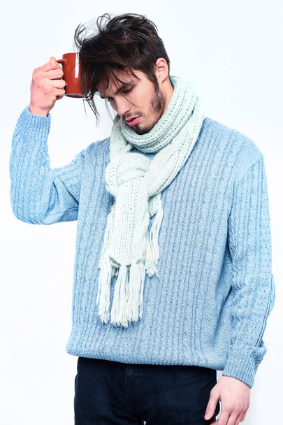 handsome bearded tired man with cup in sweater and scarf - Fotó, kép