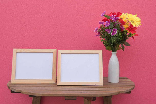 Twee foto Frame op een houten en bloemen in pot op roze achtergrond  - Foto, afbeelding