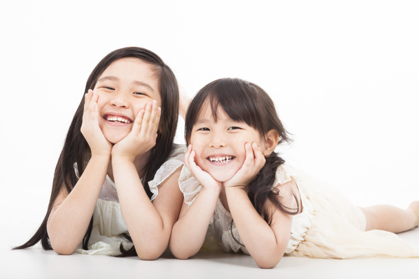 Feliz dos chicas asiáticas en el fondo blanco
 - Foto, imagen