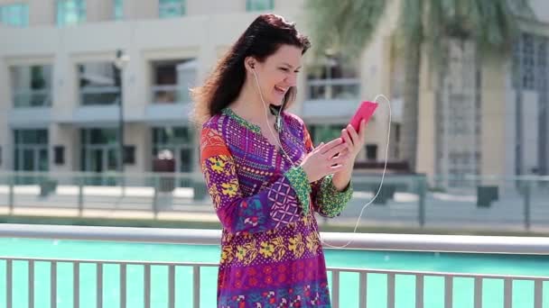 Γυναίκα με smartphone κοντά στο μπλε πισίνα   - Πλάνα, βίντεο