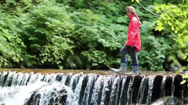 Dívka chodí podél přehrady malé přetečení  - Záběry, video