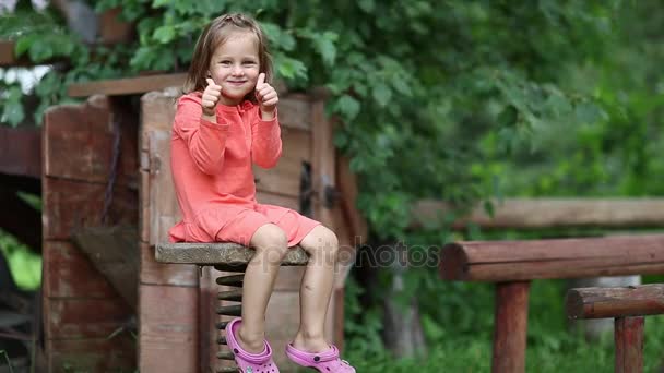 mała dziewczynka siedzi na krześle - Materiał filmowy, wideo