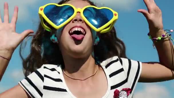 κορίτσι με τα γυαλιά κάνει αστεία πρόσωπα - Πλάνα, βίντεο