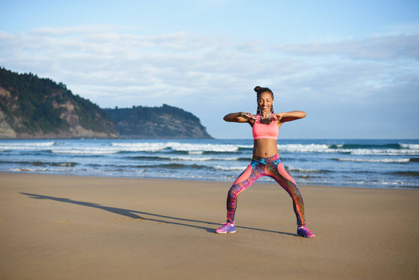 Sportieve Braziliaanse vrouw dansen en plezier op het strand - Foto, afbeelding