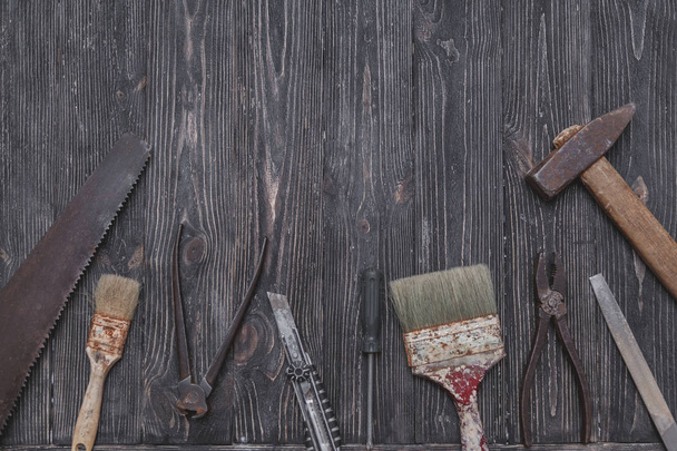 Old work tools on black wooden background. - Foto, Bild