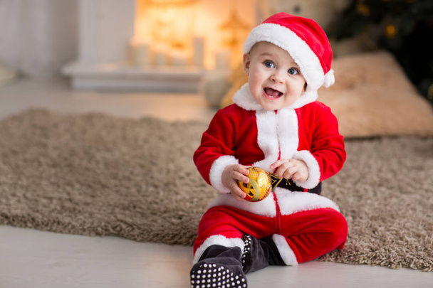 funny baby boy weared in Santa hat with golden Christmas ball - Foto, Imagem