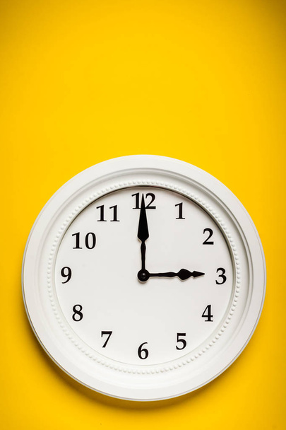 weiße Uhr auf gelbem Hintergrund - Foto, Bild