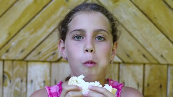 Dziewczyna zjada białe pieczywo - Materiał filmowy, wideo