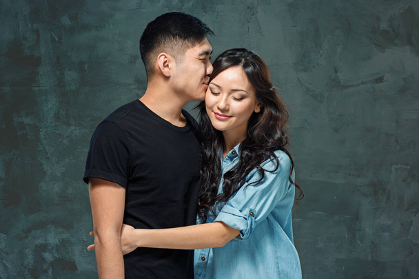 Portrait of smiling Korean couple on a gray - 写真・画像