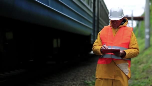 Inspektor provozu železniční dopravy dělá poznámky   - Záběry, video