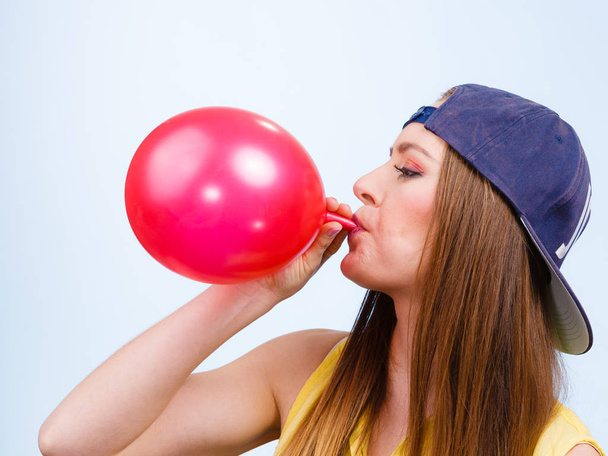 Teen girl blowing red balloon. - Foto, imagen