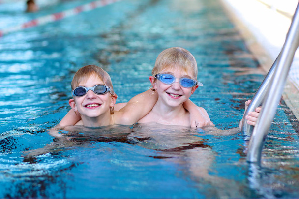Two sportive kids swimming in the pool - Фото, зображення