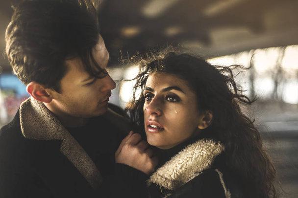 Pareja romántica afuera bajo el puente llora. Retrato de un hombre joven y una mujer joven enamorada. Foto tonificada
 - Foto, imagen