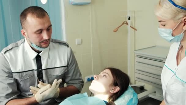 Dentista e assistente parlare con il cliente prima di trattare
. - Filmati, video