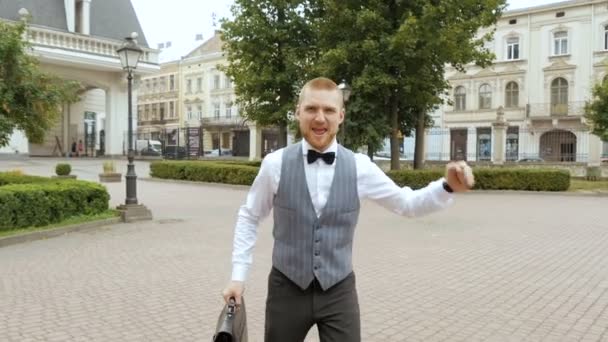 Geschäftsmann springt und läuft mit altstädtischem Hintergrund, - Filmmaterial, Video