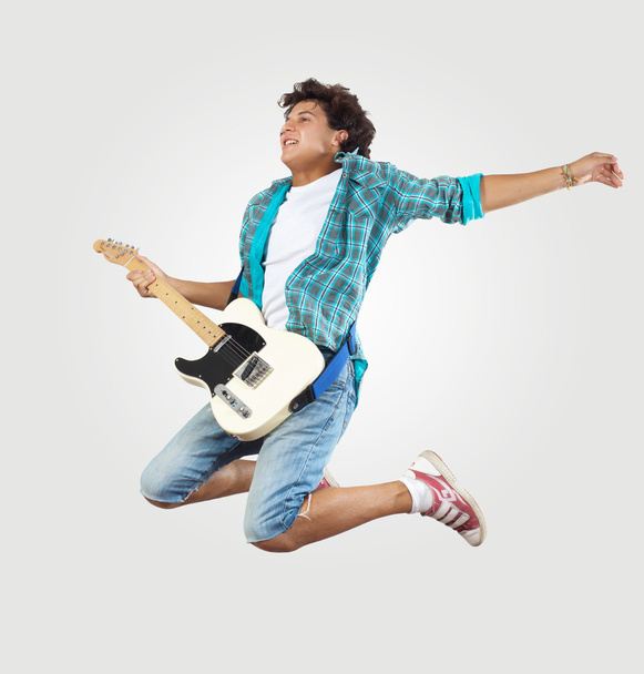 Young man playing on electro guitar and jumping - Foto, immagini