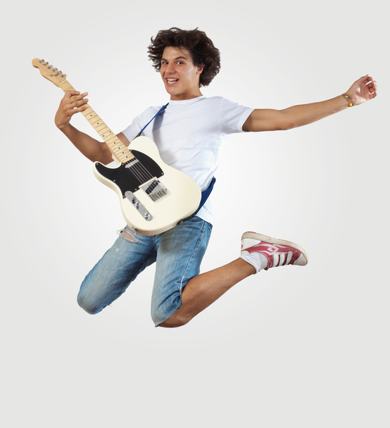 Joven tocando en la guitarra electro y saltando
 - Foto, Imagen