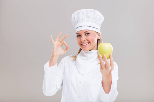 Female chef with apple - Фото, зображення