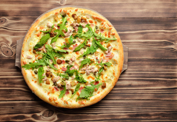 Hot big whole tasty pizza with melting cheese bacon tomatoes ham - Foto, afbeelding