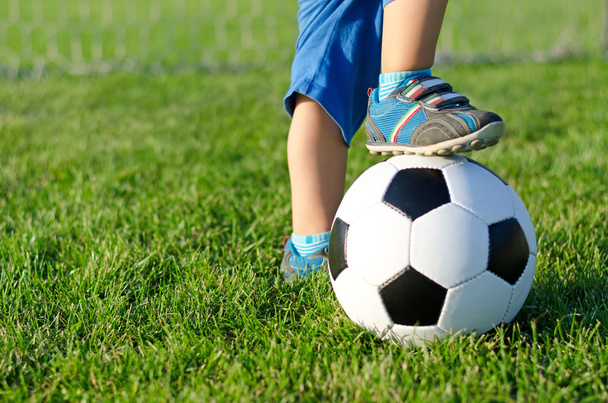 Мальчик с ногой на футбольном мяче
 - Фото, изображение