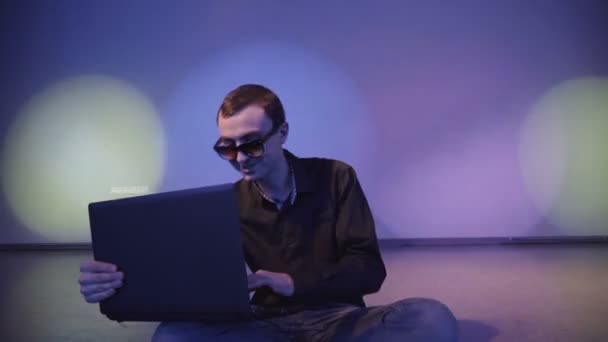 Close up van jonge gelukkig zakenman werkt op laptopcomputer onder lichte muziek - Video