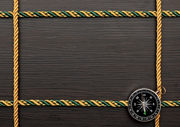 colorful rope frame with compass on wooden background - Fotó, kép