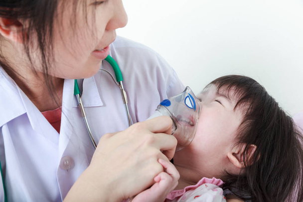 Aasialainen tyttö, jolla on hengitystiesairaus lääkärin avulla sairaalahuoneessa
. - Valokuva, kuva