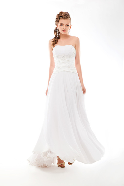 Beautiful woman in wedding dress over studio background - Фото, изображение