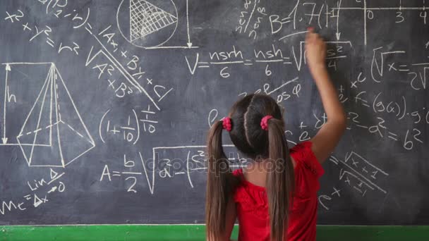 glückliches Mädchen, das im Unterricht an die Tafel schreibt und lächelt - Filmmaterial, Video