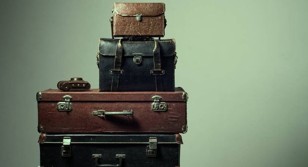 Background stack of old shabby suitcases and camera - Фото, зображення