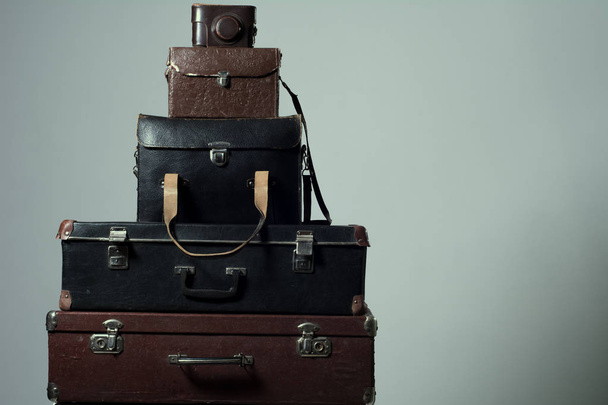 Background stack of old shabby suitcases and camera - Photo, Image